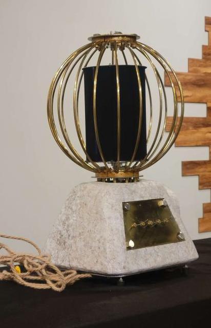 An imager device consisting of a sphere of brass bars with a black cylinder inside.