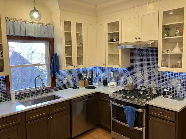Right-hand view of the same kitchen with stuff on the counters and the cabinets.