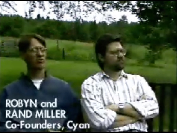 Robyn and Rand Miller sitting on a bench outdoors, circa 1993. The resolution is terrible and everything is rather green-shifted.