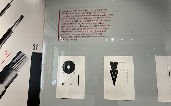 Two full-page advertisements with large black shapes contrasting with narrow lines of Dutch text running at all angles. The blurb above begins, "Zwart's collaboration with the Nederlandse Kabelfabriek Delft (NKF) from 1923 to 1928 transformed an ordinary industrial manufacturer into an icon of modern design."